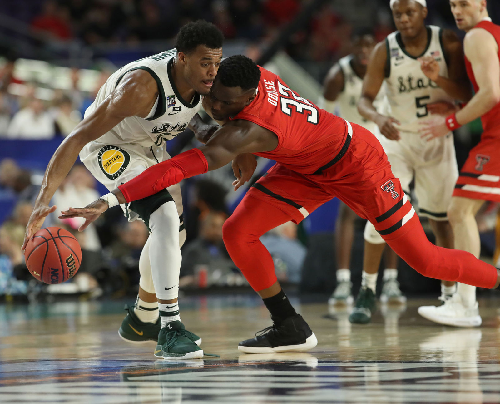 Texas Tech's Norense Odiase (32) reaches for the ball against Michigan State's Xavier Tillman (23) during the first half in a semifinal of the NCAA Tournament Final Four on Saturday, April 6, 2019, at U.S. Bank Stadium in Minneapolis.